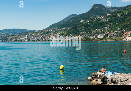 Blick auf den idyllischen Ufer des Genfer Sees und der Montreux Riviera mit Menschen subathing auf einem Bea Stockfoto