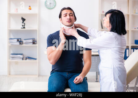 Junge männliche Patienten im Alter besuchen Ärztin Stockfoto