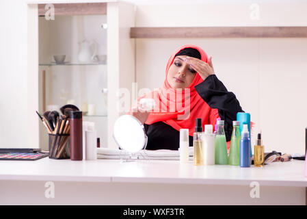 Schöne Frau im hijab Anwendung Make-up Stockfoto