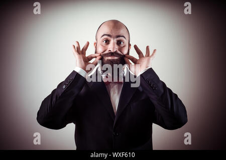 Lustige eleganten bärtigen Mann berühren Schnurrbart auf Vignettierung Hintergrund Stockfoto