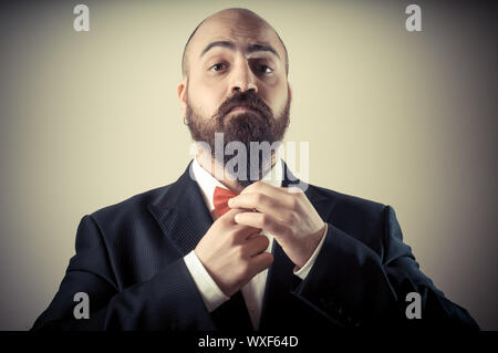 Lustige eleganten bärtigen Mann berühren Bart auf Vignettierung Hintergrund Stockfoto