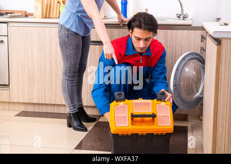 Junge männliche Handwerker Reparatur Waschmaschine Stockfoto