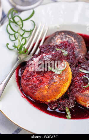 Quark Pfannkuchen mit kirschsauce mit Rosmarin. Stockfoto