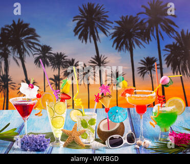 Viele bunte tropische Cocktails in tropisch blau Holz Palm-Baum-Sonnenuntergang mit Kokosnuss Mojito Pepermint margarita Stockfoto