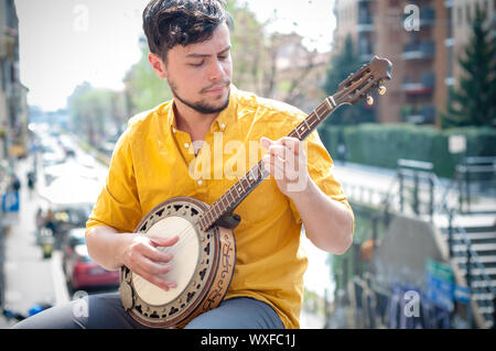 Hipster junge Mann spielt Banjo in der Stadt Stockfoto