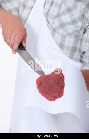 Ein Metzger, ein Stück Fleisch anzeigen Stockfoto