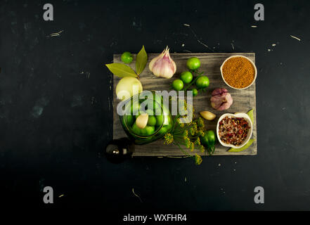 Gemüse, Tomaten und Gewürzen auf der Platine. Zwiebeln Knoblauch Tomaten, Dill, GEWÜRZE AUF GRAU HOLZBRETT AUF EINEM ERHÖHTEN STEIN Oberfläche. Stockfoto