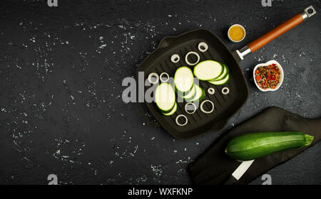 Frische grüne Zucchini auf einen dunklen Tisch. Die Aussicht von oben. Kopieren Sie Platz. Stockfoto