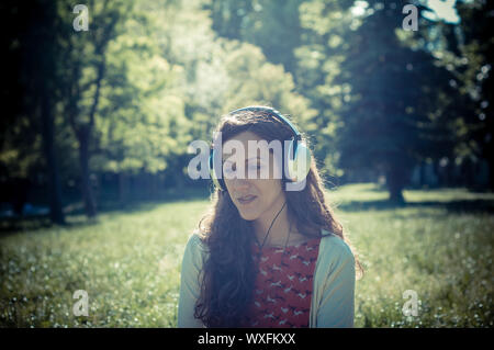 Vintage Hippie östliche frau mit Kopfhörer im Park Stockfoto