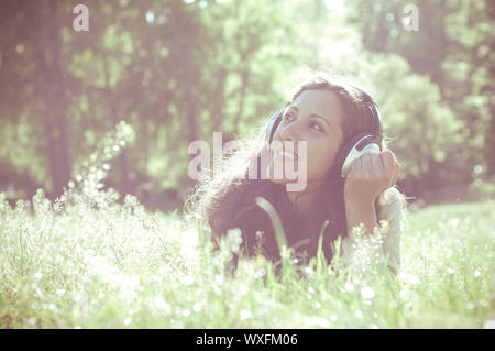 Vintage Hippie östliche frau mit Kopfhörer im Park Stockfoto