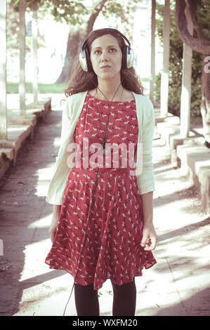 Vintage Hippie östliche frau mit Kopfhörer im Park Stockfoto