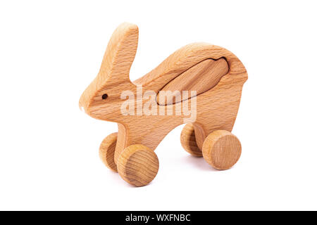 Foto von einem hölzernen Hase mit Karotte auf Rädern der Buche. Spielzeug aus Holz auf einem weißen Hintergrund isoliert. ein Spielzeug für die Unterhaltung der Kinder und ruht aus. Stockfoto