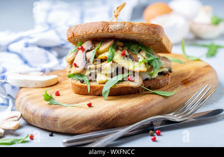 Sandwich mit Pilzen und Rührei zum Frühstück. Stockfoto