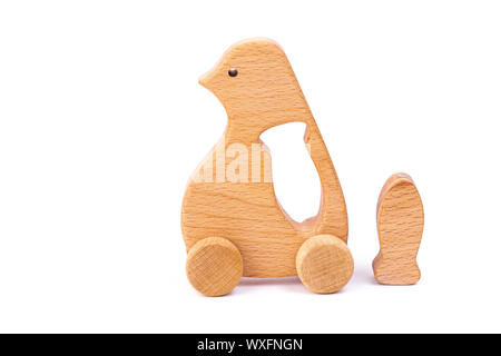 Foto von einem hölzernen Pinguin mit Fisch auf Rädern der Buche. Spielzeug aus Holz auf einem weißen Hintergrund isoliert. ein Spielzeug für die Unterhaltung der Kinder und ruht aus. Stockfoto