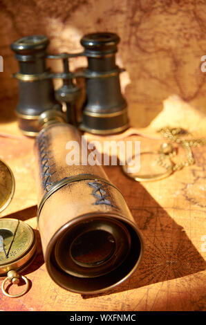 Alte Fernglas und Teleskop liegen auf der Karte Stockfoto