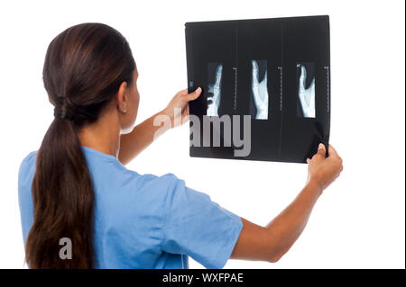 Junge Ärztin Analyse x-ray Blatt ihre Patienten, Rückansicht Stockfoto
