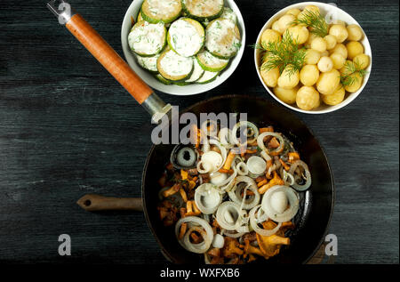 Gemüse auf dem Hintergrund. Gebratene zucchini Sauce in einen Teller. Junge gekochte Kartoffeln mit Dill in eine Schüssel geben. Gebratene Pfifferlinge Brei Stockfoto