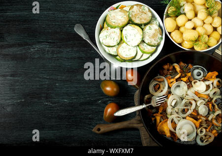 Gemüse auf dem Hintergrund. Gebratene zucchini Sauce in einen Teller. Junge gekochte Kartoffeln mit Dill in eine Schüssel geben. Gebratene Pfifferlinge Brei Stockfoto
