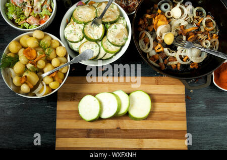 Gemüse auf dem Hintergrund. Gebratene zucchini Sauce in einen Teller. Junge gekochte Kartoffeln mit Dill in eine Schüssel geben. Gebratene Pfifferlinge Brei Stockfoto
