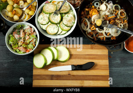 Gemüse auf dem Hintergrund. Gebratene zucchini Sauce in einen Teller. Junge gekochte Kartoffeln mit Dill in eine Schüssel geben. Gebratene Pfifferlinge Brei Stockfoto