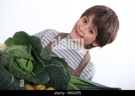 Kleiner Junge mit einer Auswahl an frischen Produkten Stockfoto