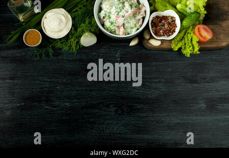 Salat mit Gemüse. Blick von oben. Frischer Salat in eine Platte auf einem dunklen Hintergrund. Knoblauch Stockfoto
