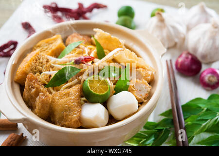 Heiß und würzig Singapur laksa Curry Nudeln oder Mee mit heißem Dampf im Tontopf, Dekoration Einrichtung, Dienen mit Stäbchen. Singapurische Küche. Stockfoto