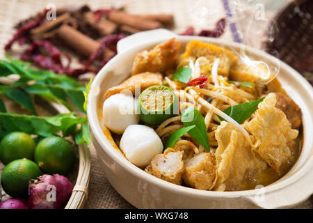 Heiß und würzig Malaysia Curry Nudeln oder laksa Mee mit heißem Dampf im Tontopf, Dekoration Einrichtung, Dienen mit Stäbchen. Malaysische Küche. Stockfoto