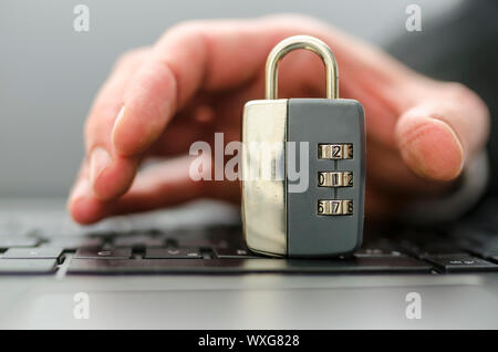 Männliche hand Vorhängeschloss aus stehlen Computer Tastatur. Stockfoto