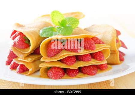 Erdbeere Crêpe oder Pfannkuchen mit Ahornsirup im Inneren. Stockfoto