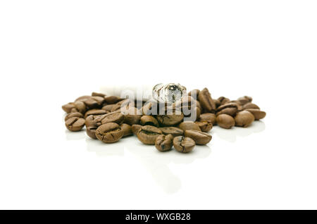 Zigarette auf Kaffee Körner. Konzept der ungesunden Gewohnheiten. Stockfoto