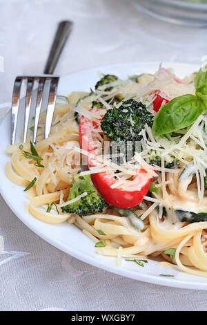 Pasta Primavera mit frischen Brokkoli, Spargel, rote Paprika und Zucchini mit frisch geriebenem Parmesan. Stockfoto