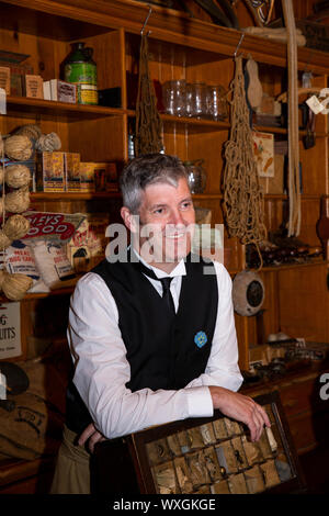 UK, County Durham, Beamish, Museum, Stadt, kostümierte freiwillig hinter Counter von Annfield Plain industrielle Co-Op shop Stockfoto