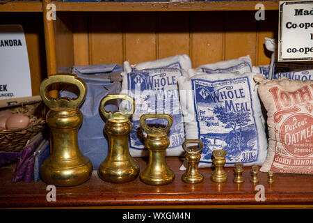 UK, County Durham, Beamish, Museum, Stadt, Annfield Plain industrielle Co-Op shop, Bestimmungen Abteilung, Regal von Mehl Taschen mit abgestuften Messing Gewicht Stockfoto