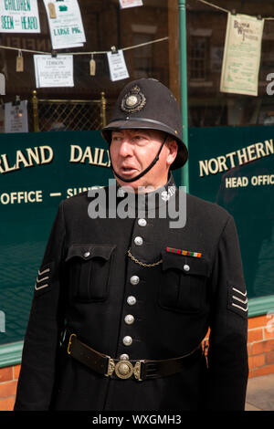 UK, County Durham, Beamish, Museum, Stadt, Main Street, Polizei Sergeant auf Aufgabe außerhalb der Zeitung Büro Stockfoto