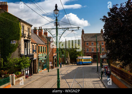 UK, County Durham, Beamish, Museum, Stadt, Main Street mit ihren Geschäften und Straßenbahn Stockfoto