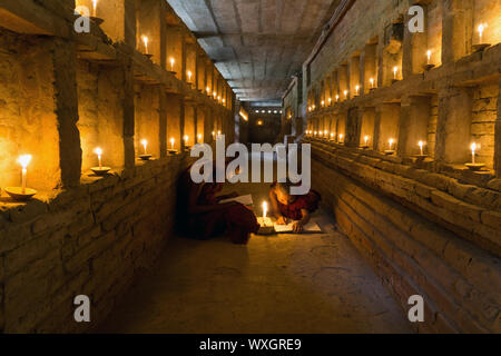 Anfänger buddhistische Mönche Studie in alten Pagode Tempel bei Kerzenschein. Stockfoto