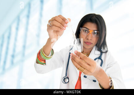 Eine indische wissenschaftliche Forscherin in einer flüssigen Lösung in einem Labor. Stockfoto