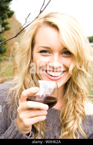 Frau trinkt Wein im Weinberg Stockfoto