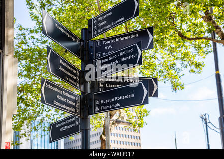 Rotterdam, Niederlande. Juni 27, 2019. Straße Richtung Wegweiser Vor einen Baum. Sonnenlicht und im städtischen Hintergrund, die Ansicht zu schließen. Stockfoto