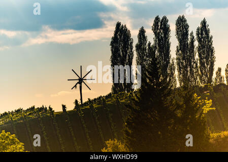 Blick auf der Wind Mühle auf dem Weinberg der Südsteirischen Weinstraße in Österreich im Sonnenuntergang. Glanz an der Weinstrasse. Stockfoto