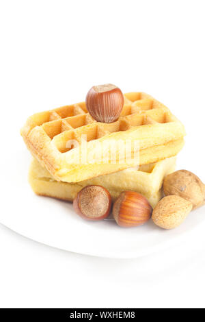Belgische Waffeln und Muttern auf einer Platte isoliert auf weiss Stockfoto
