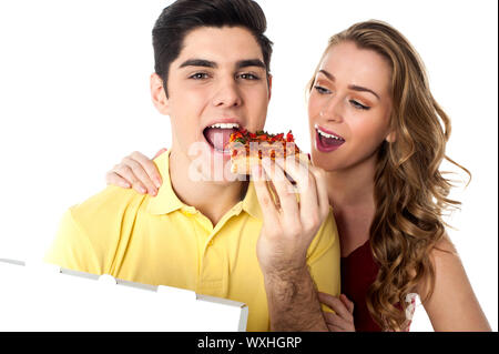 Hungrige junge Paar genießt ein Stück pizza Stockfoto