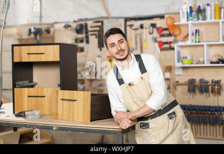 Möbelfabrik, kleines Unternehmen und Personen Konzept - Porträt eines lächelnden männlichen Arbeitnehmer bei der Herstellung Stockfoto