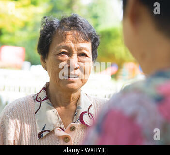 Asiatische 80er Jahre alte Frauen mit Gespräch im Outdoor-Park, ehrliche erschossen. Stockfoto