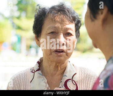 Traurigkeit senior Frau zu ihrer Freundin, mit Tränen in den Augen, im freien Naturpark traurige Geschichte zu erzählen. Stockfoto