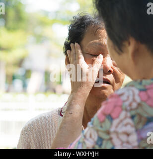 Reportageaufnahme einer reifen Frau tröstende Tränen weinen alte Mutter bei Outdoor-Naturpark. Stockfoto