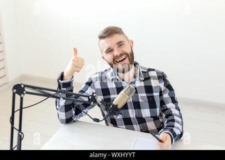 Radio Host, Streamer und blogger Konzept - Portrait von lächelnden Mann deutete Daumen hoch, Hosting eine Show bei Radio Station oder seinen Blog Stockfoto