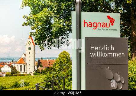 Panoramablick auf den Bodensee. Zeppelin, Apfelbäume und die Katholische Kirche St. Johann Baptist in Hagnau am Bild. Stockfoto