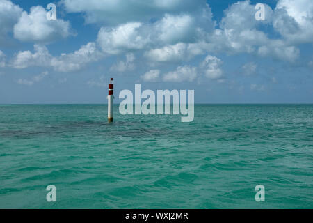 Türkis, Karibische Meer mit Horizont halb und halb mit blauem Himmel und weissen flauschigen Wolken Stockfoto